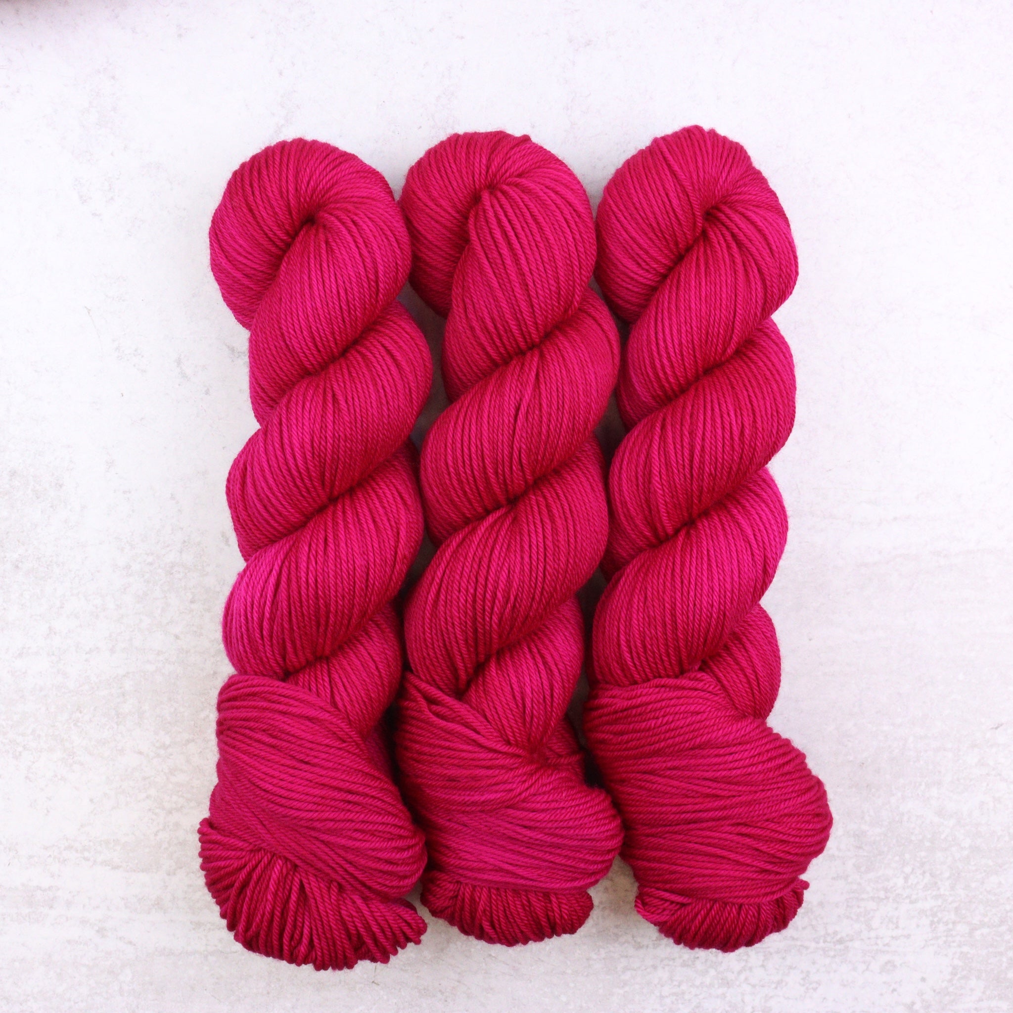 Hand dyed semi solid Dk weight yarn in a vibrant Magenta Pink
