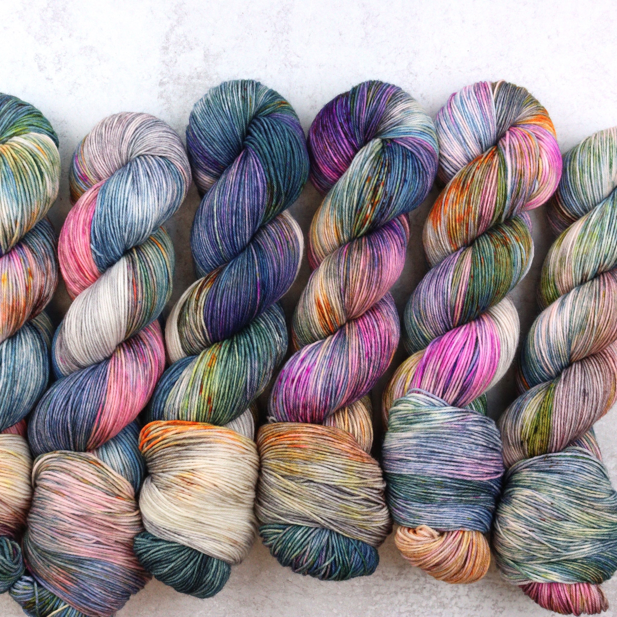 Hand dyed yarn by Spun Right Round. Featuring blue, pink, orange, green, aqua and brown.