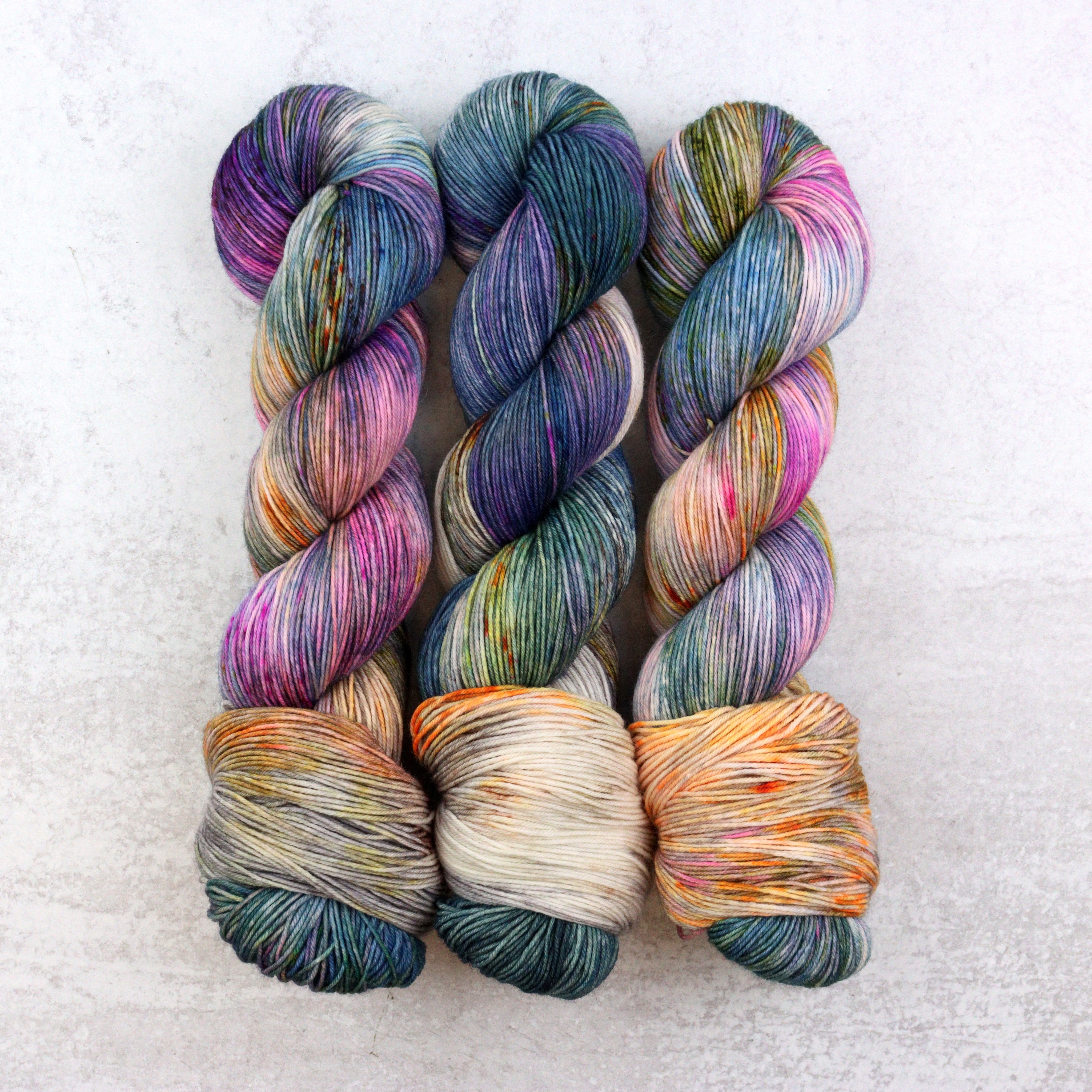 Hand dyed yarn by Spun Right Round. Featuring blue, pink, orange, green, aqua and brown.
