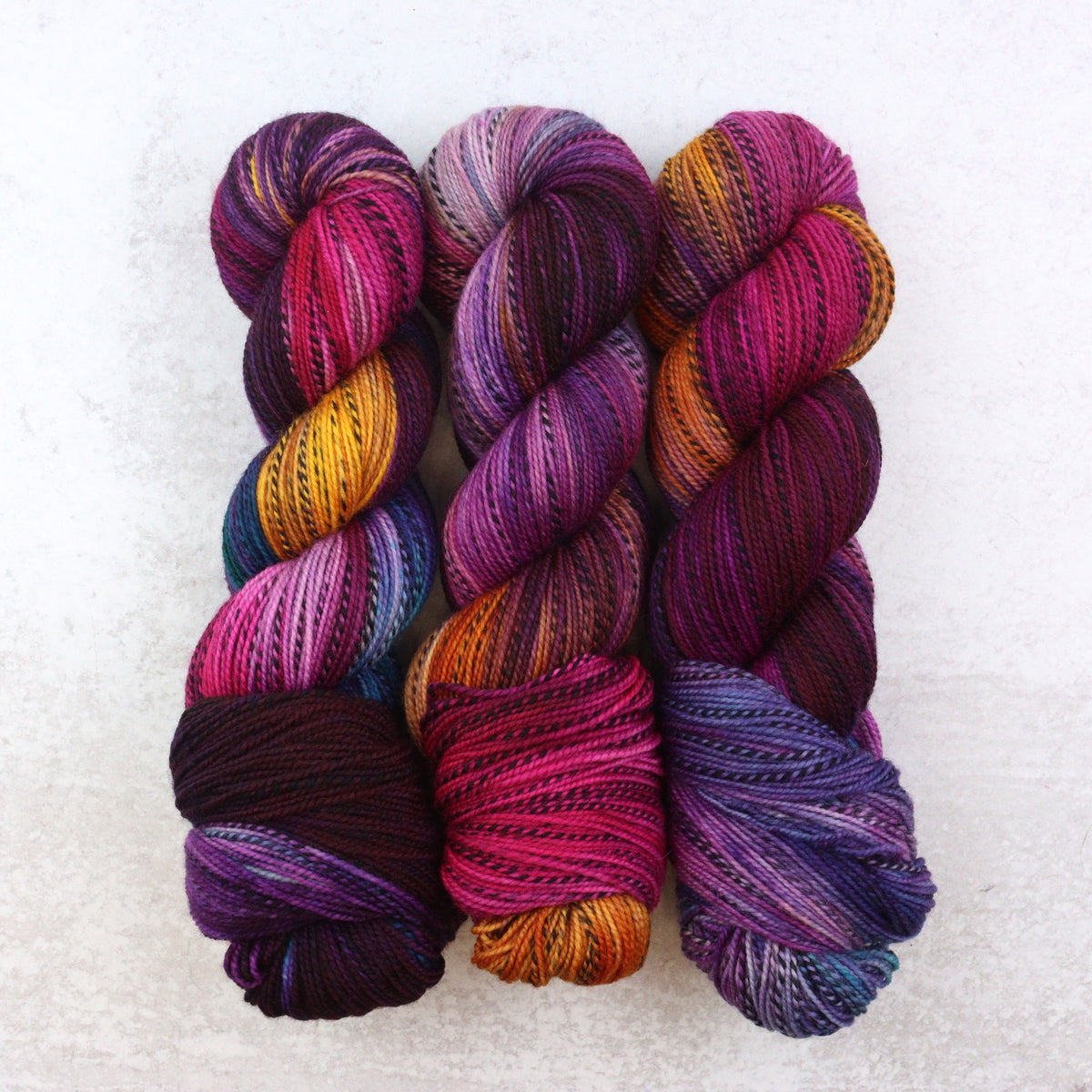 jewel toned variegated hand dyed yarn with splashes of orange, purple and blue.