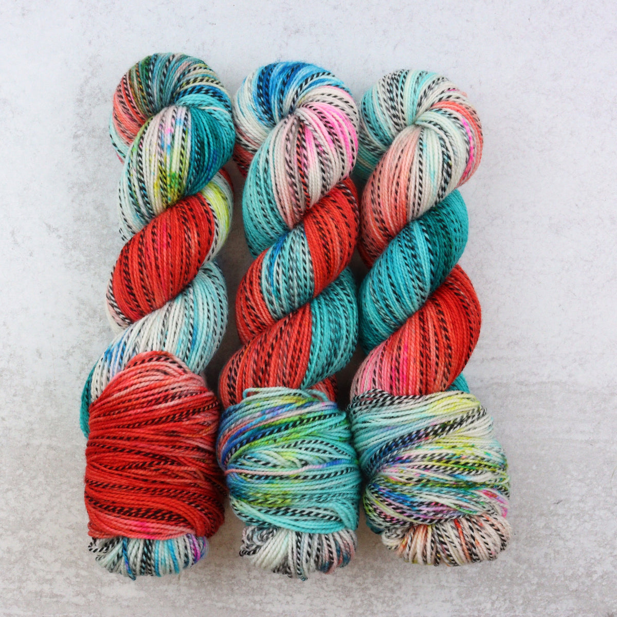 Hand dyed yarn in red, aqua, green pink and orange.