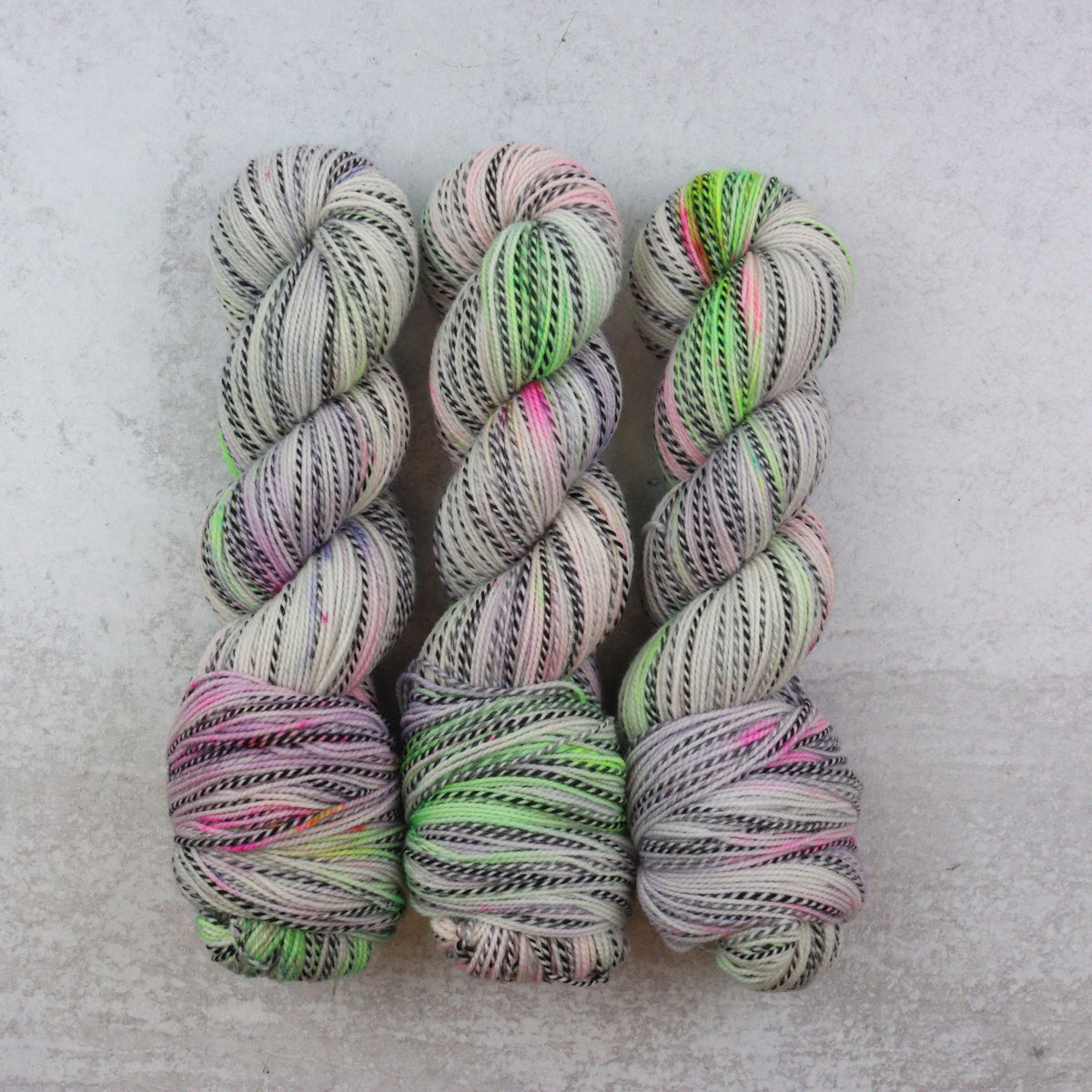 softly speckled sock yarn in green, pink and purple.