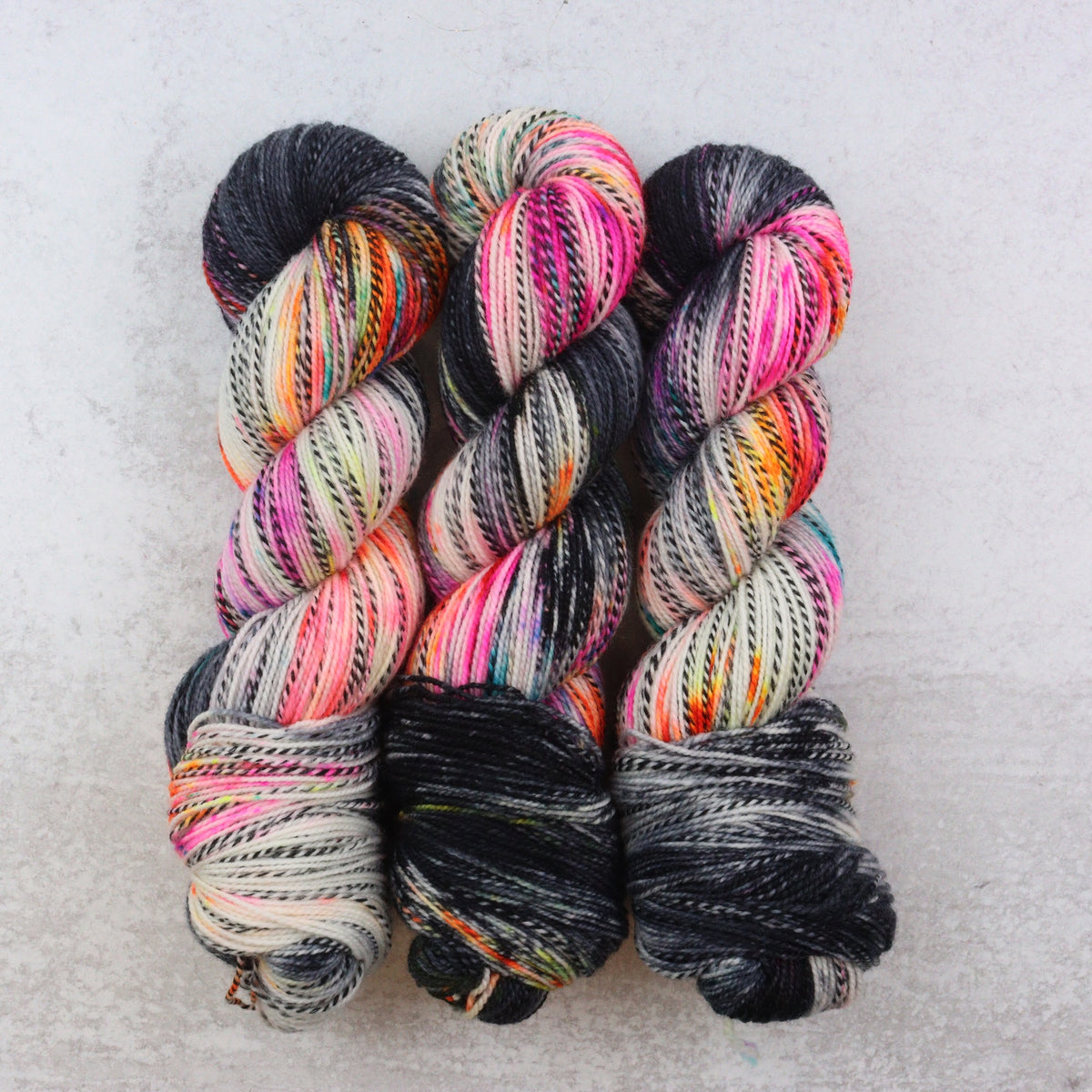 Hand dyed sock yarn in black, orange, pink and aqua.
