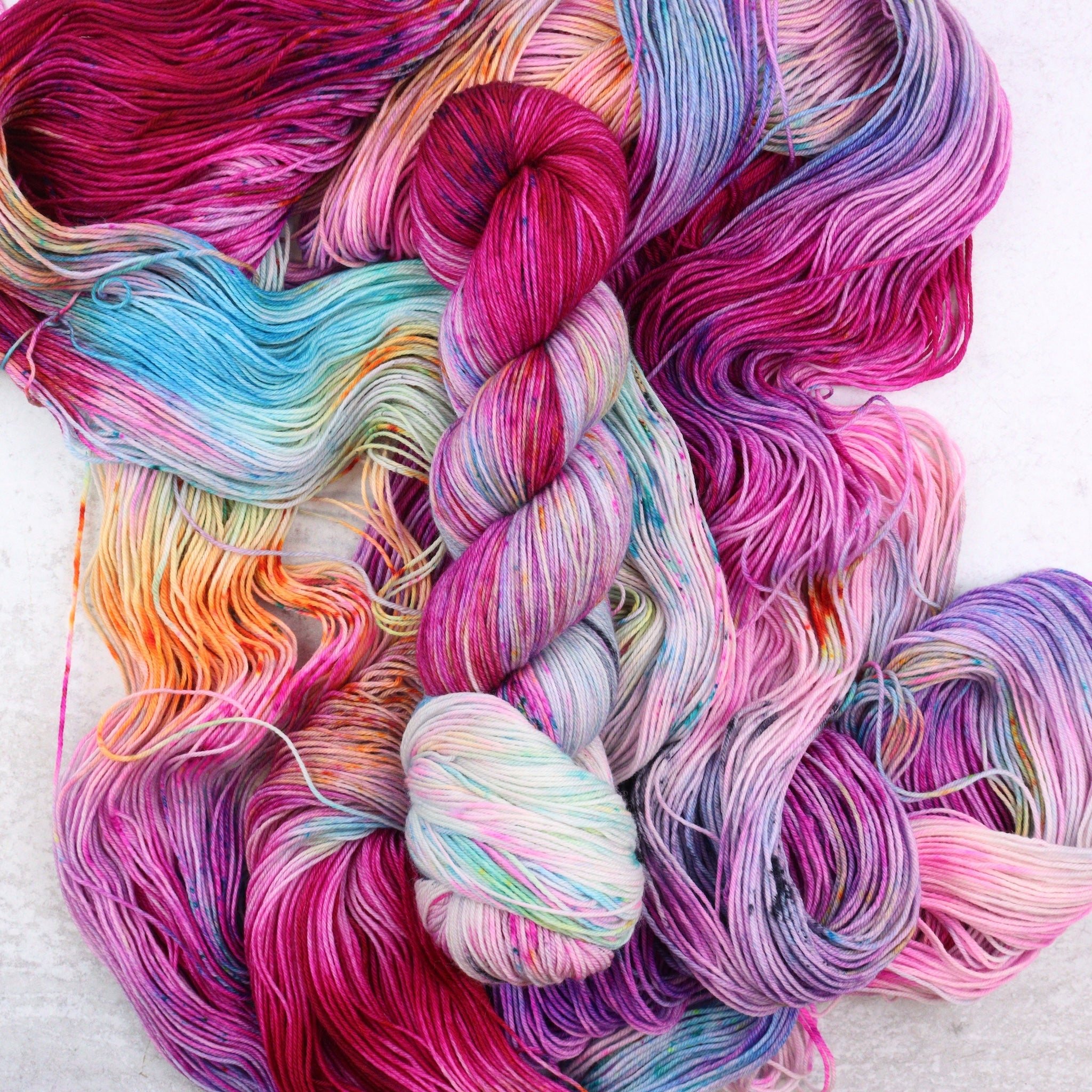 Popsicle is a brightly hand dyed yarn with pops of red, pink, aqua, orange and charcoal.