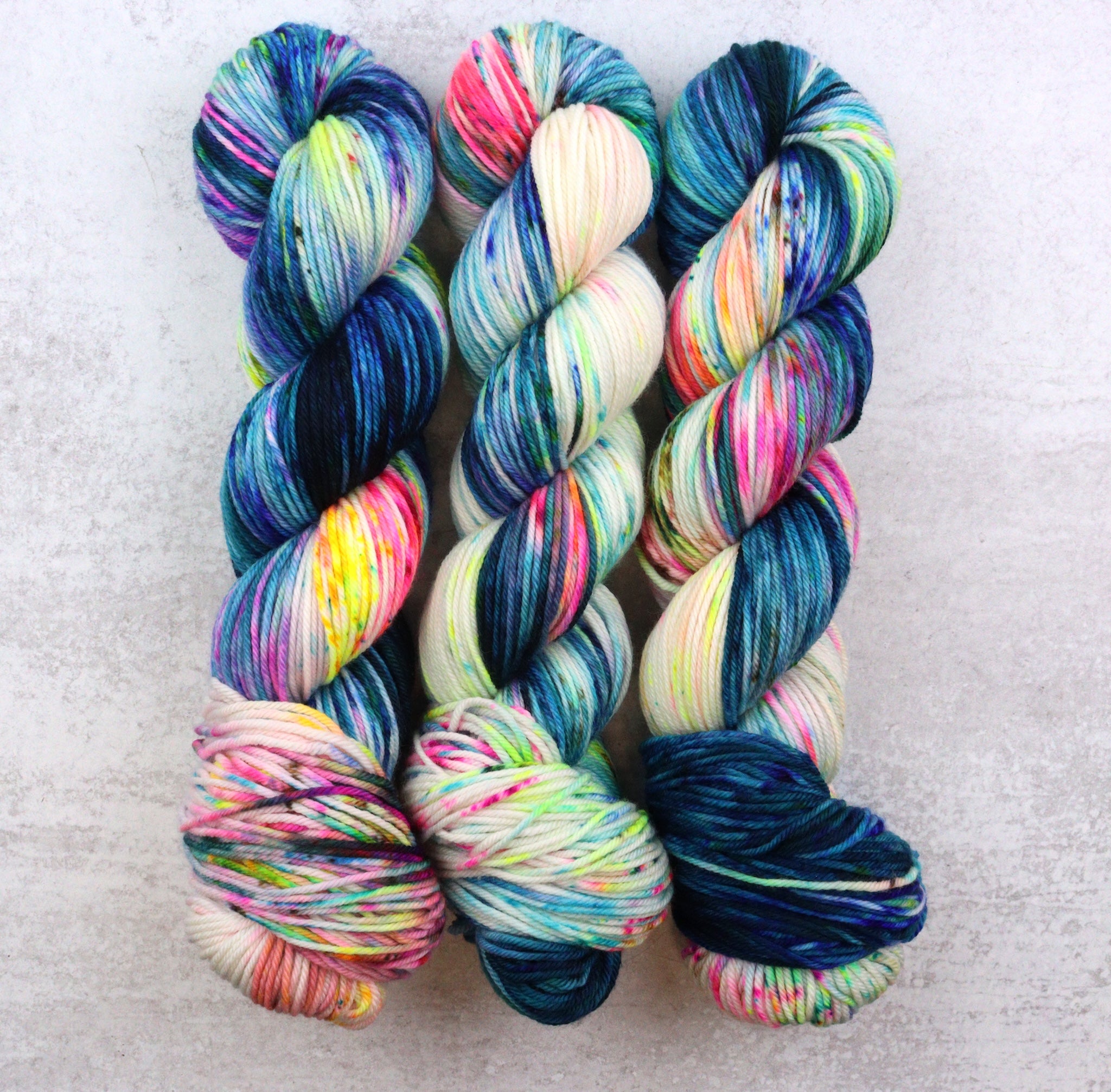 Vibrant hand dyed yarn in blue, yellow, pink and green. 