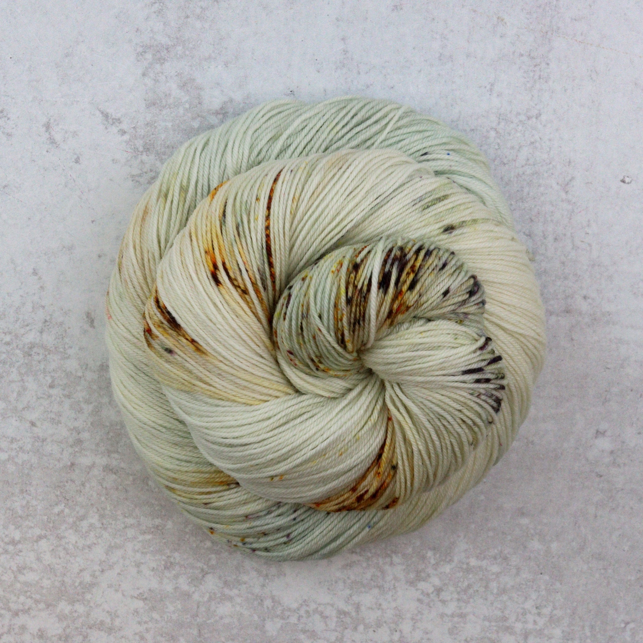 Hand dyed speckled skeins of superwash merino sock yarn.