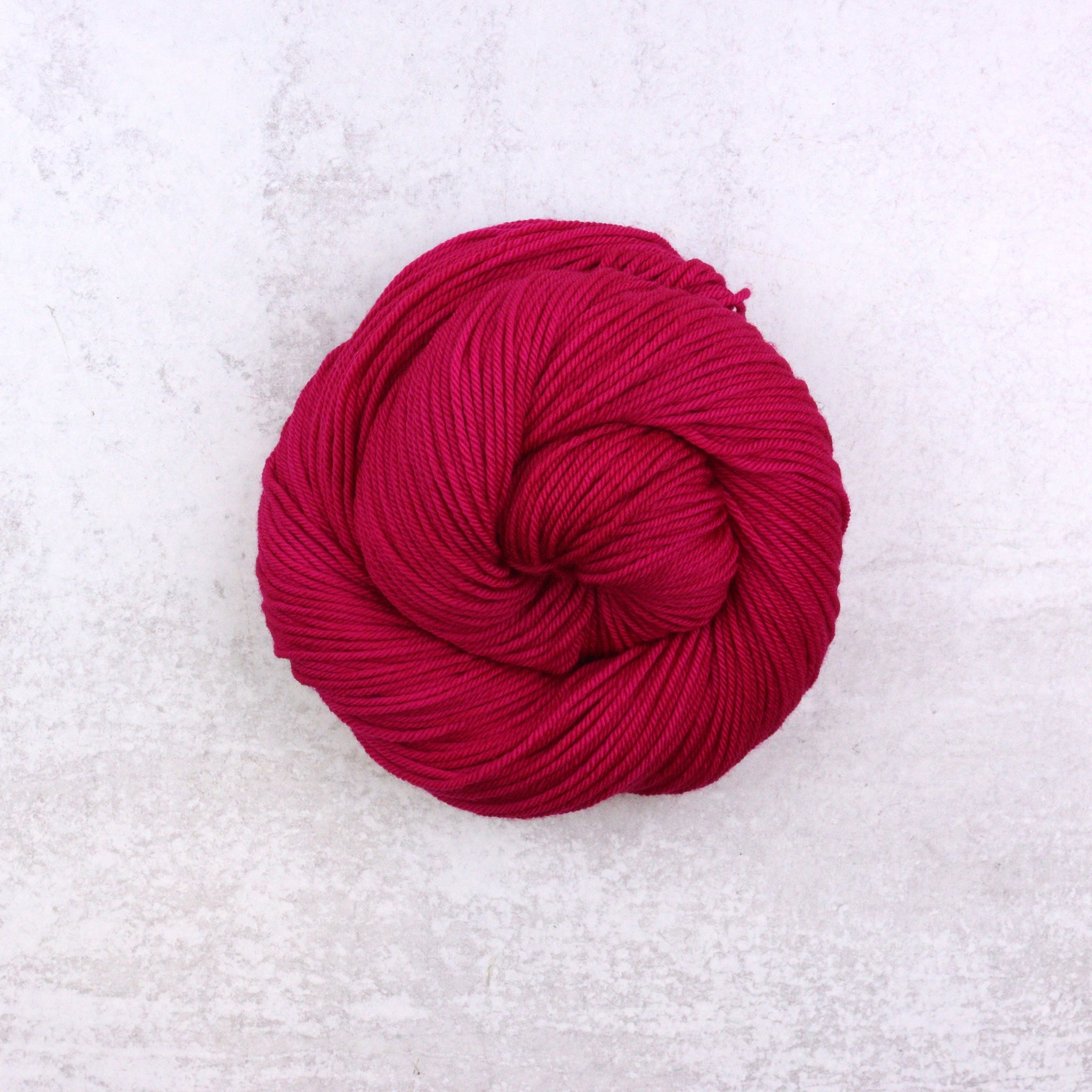 Hand dyed semi solid Dk weight yarn in a vibrant Magenta Pink