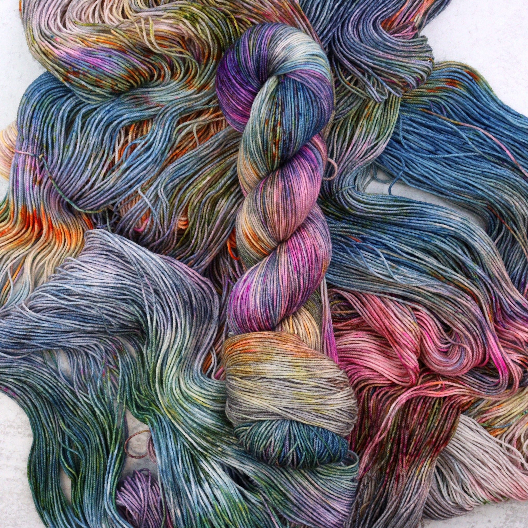 Hand dyed yarn by Spun Right Round. Featuring blue, pink, orange, green, aqua and brown.