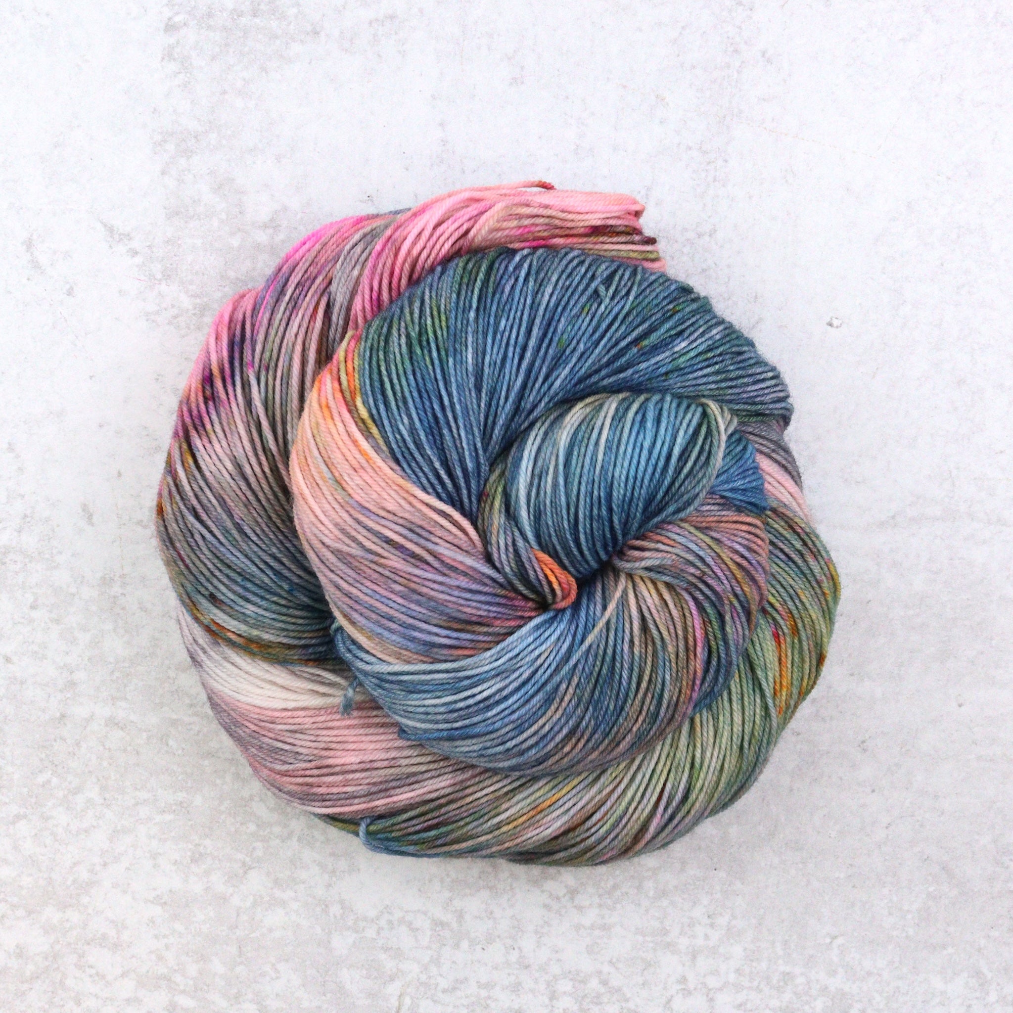 Hand dyed yarn by Spun Right Round. Featuring blue, pink, orange, green, aqua and brown.
