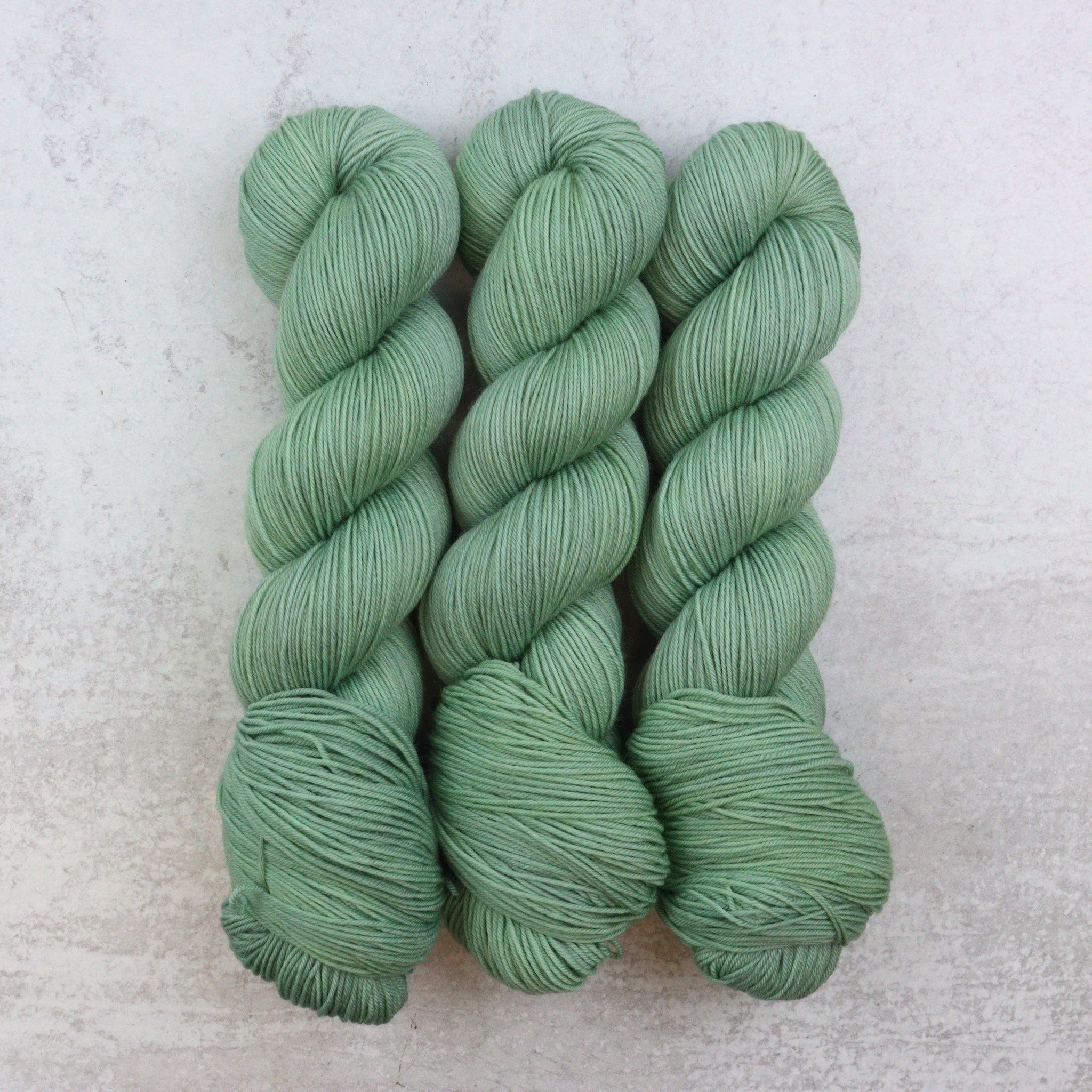 There skeins of light green hand dyed yarn
