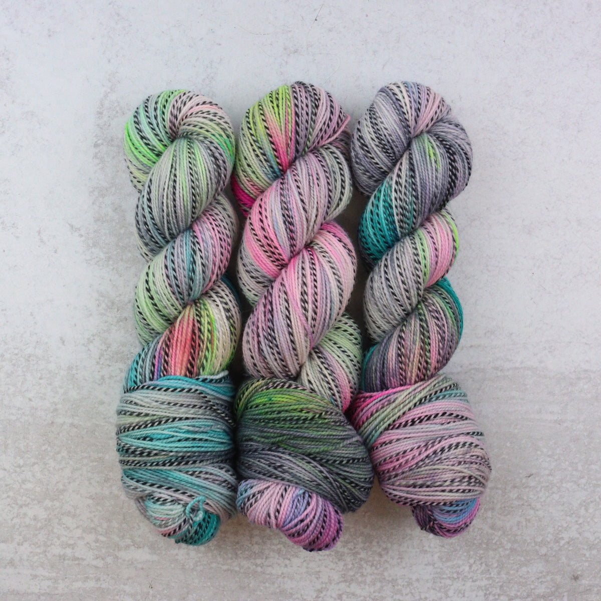 Softly speckled hand dyed yarn in grey, pink, aqua and green.