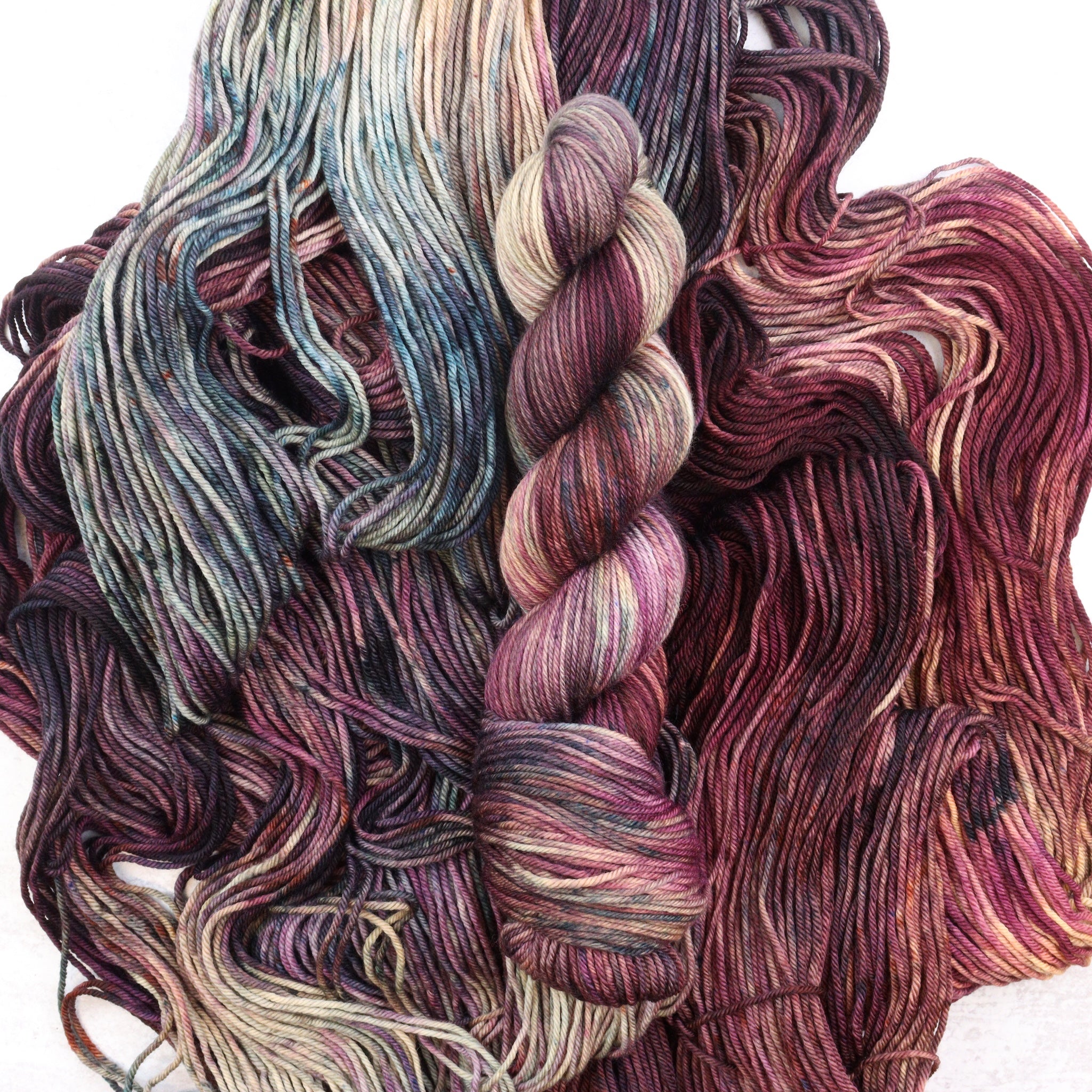 Variegated hand dyed DK weight yarn in brown, purple and teal by Spun Right Round.